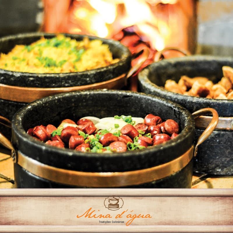 Buffet variado com tradicional cozinha mineira feita em fogão a lenha, bebidas variadas e clima familiar.
