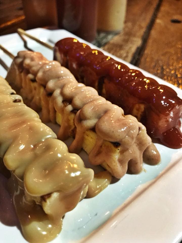 Variedade de cervejas e espetinhos de carne, frango, legumes e queijos, em espaço descontraído com quintal.