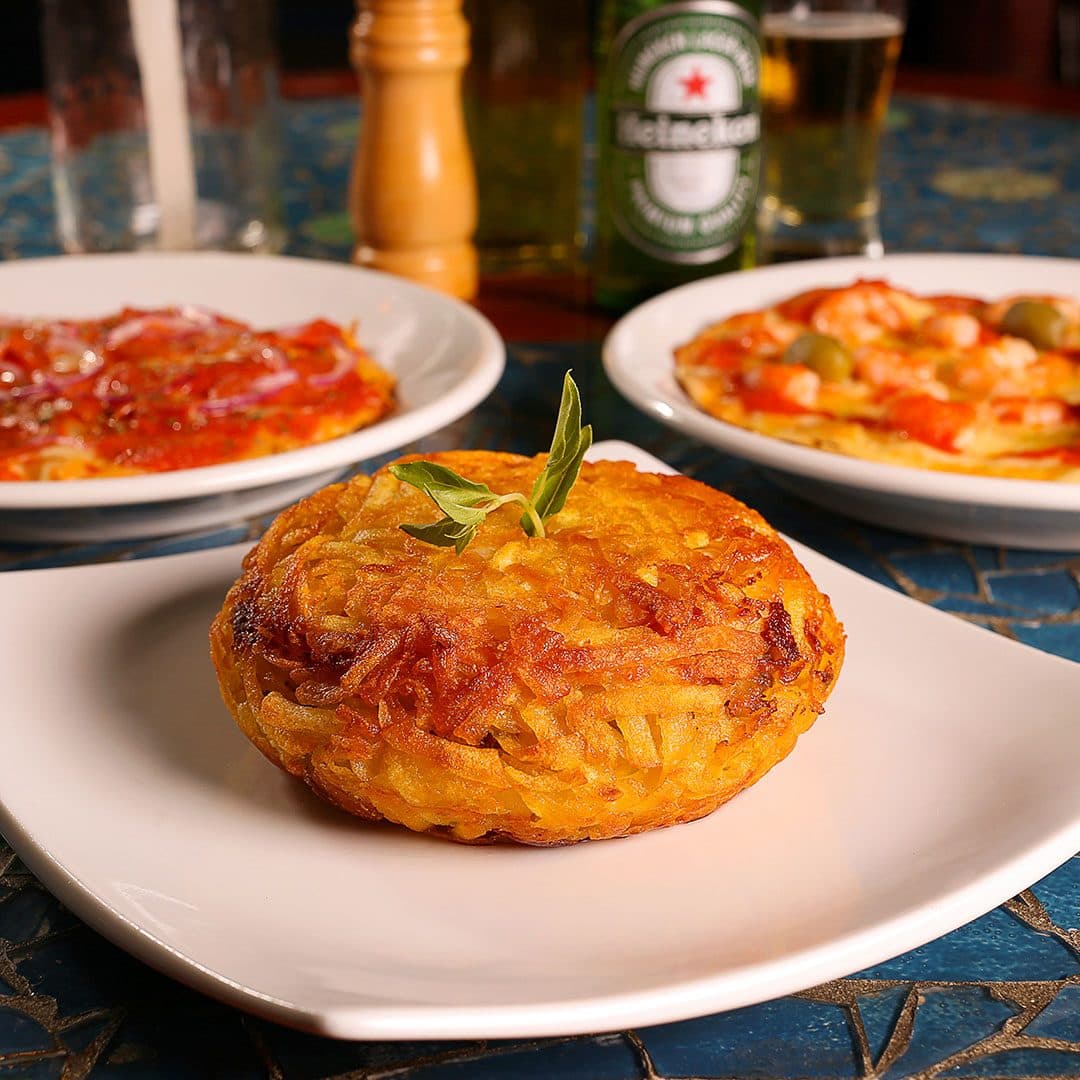 Pizzas artesanais, batatas e cervejas, em ambiente boêmio e rústico, repleto de arte e com velas nas mesas.