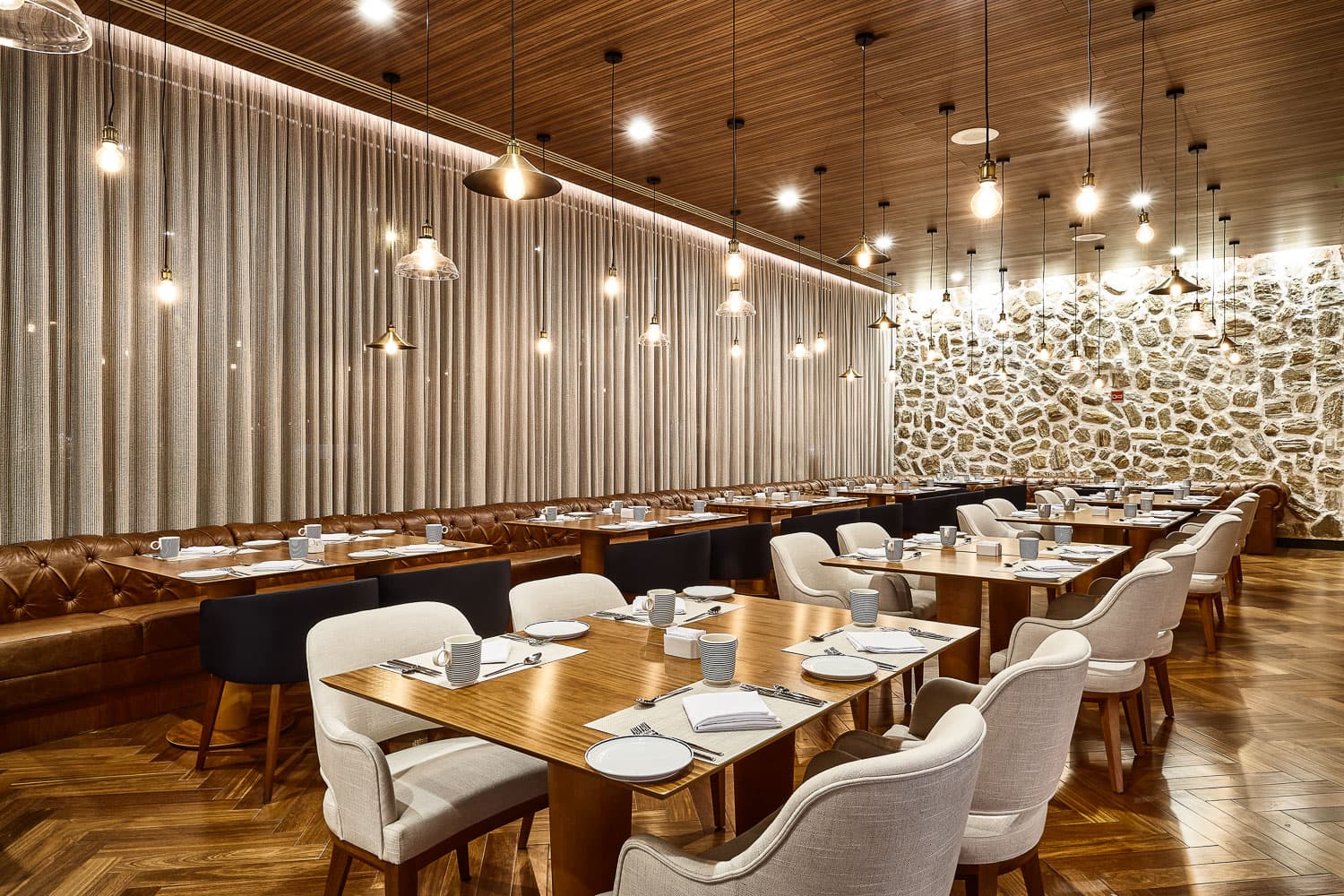 Clássicos da cozinha lusitana, vinhos, decoração rústica e moderna, parede de pedras e ambiente elegante.