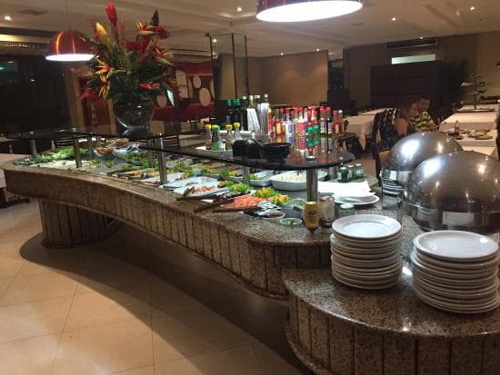 Cortes nobres do sul no espeto acompanham amplo buffet de opções variadas em restaurante espaçoso com vista.