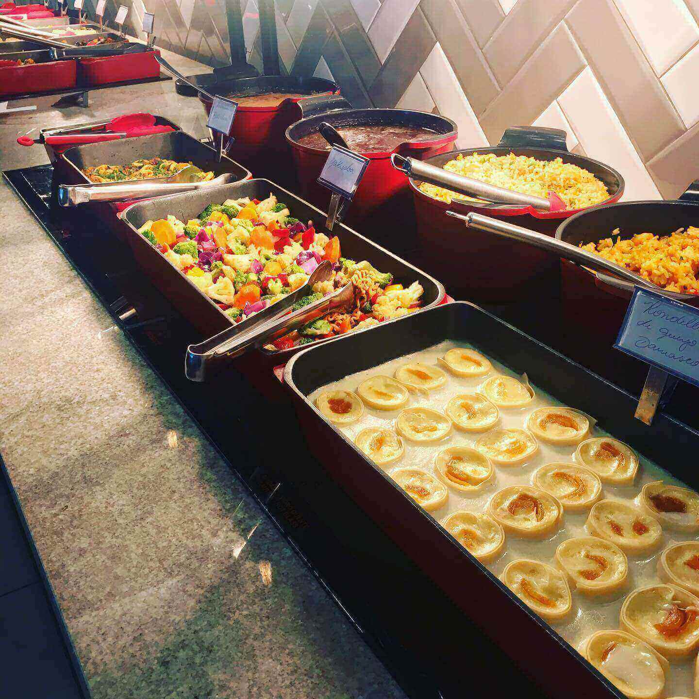 Saladas e pratos quentes variados, além de grelhados, em restaurante self-service espaçoso e contemporâneo.