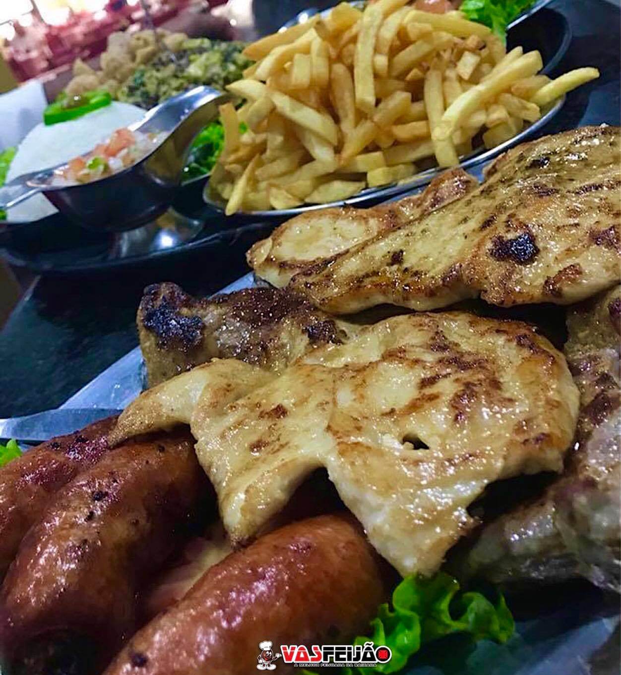Bar com bolinho de feijoada, picanha na chapa com feijão tropeiro, churrasco, chopes e clima descontraído.