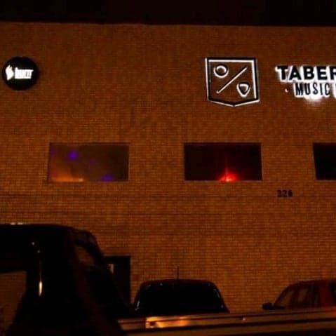 Coquetéis e cervejas, além da música ao vivo, em bar aconchegante com decoração rústica e atmosfera alegre.