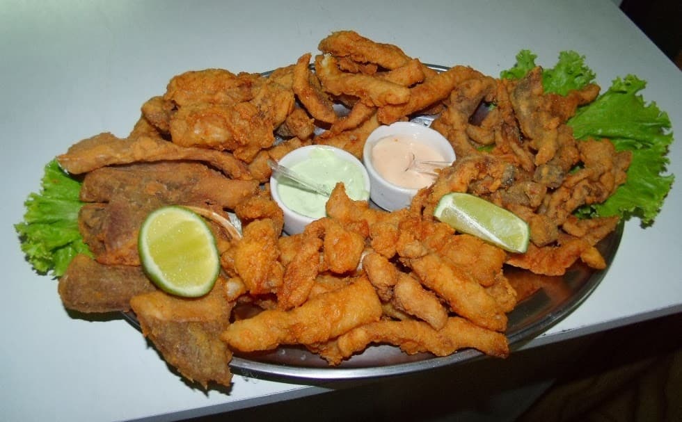 A cozinha regional à la carte de peixes de água doce em cabana boêmia despojada de recinto sob cobertura.