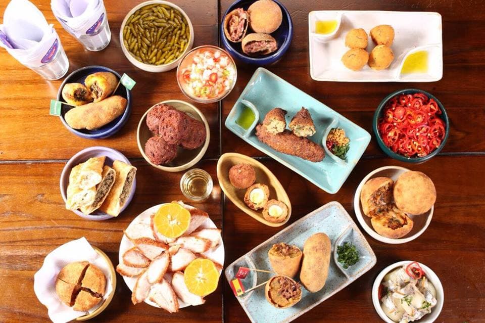 Boemia clássica serve a cozinha brasileira seleta de petiscos tradicionais e cervejas com mesas ao ar livre.