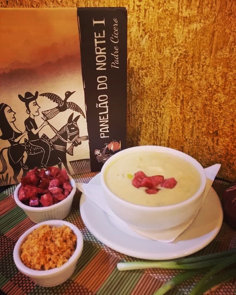 Cozinha nordestina com música traz ícones sertanejos da caatinga servindo pratos e especialidades do sertão.