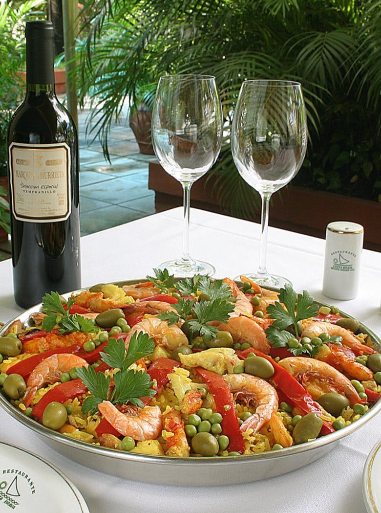 Paella com camarões, bacalhau e peixes grelhados, além de vinhos importados, em espaço espanhol elegante.