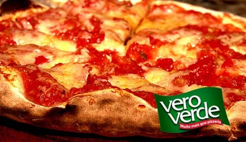 Em 1982, Osvaldo d’ Andrea idealizou uma pizzaria em que o ambiente fosse acolhedor e que unisse simplicidade e descontração. Um lugar em que as pessoas pudessem saborear confortavelmente as melhores pizzas da região com suas famílias e amigos. Para concretizar essa idéia, juntou-se a ele seu irmão Ernesto, e então, os d’Andrea voltaram sua atenção à qualidade das pizzas, o que se tornou, indiscutivelmente, a marca registrada da casa. Elaboradas com todo o cuidado, da massa crocante ao farto recheio e, assadas em fornos à lenha, suas pizzas marcaram época pelo sabor e também pela inovação. A Vero Verde foi a primeira pizzaria da região a fazer a pizza de Catupiry, um enorme sucesso, que até hoje está entre as mais apreciadas. Mas o segredo de uma boa pizza também está em quem literalmente põe as mãos na massa. A pizzaria tem funcionários em sua cozinha que estão na casa há 25 anos e que já são parte da “família Vero Verde”. Pioneira também no serviço de delivery e a fazer o “Festa em Casa”, ao longo desses anos, a Vero Verde Pizzaria cresceu, ampliou seu salão e, com o Pizza Bar, inaugurado em 1998, passou a contar com 510 lugares. Tornou-se uma casa ampla e despojada, cuja decoração atrai clientes de toda a região, inclusive boa parte de São Paulo.