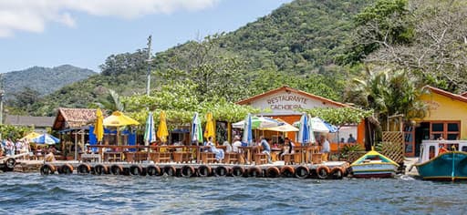 Restaurante familiar de frutos do mar em receitas regionais diversas com área sombreada externa e deck.
