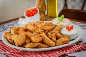 Petiscos típicos de boteco e geladas, destaque às pizzas e à Carne de Onça, ambiente descontraído.
