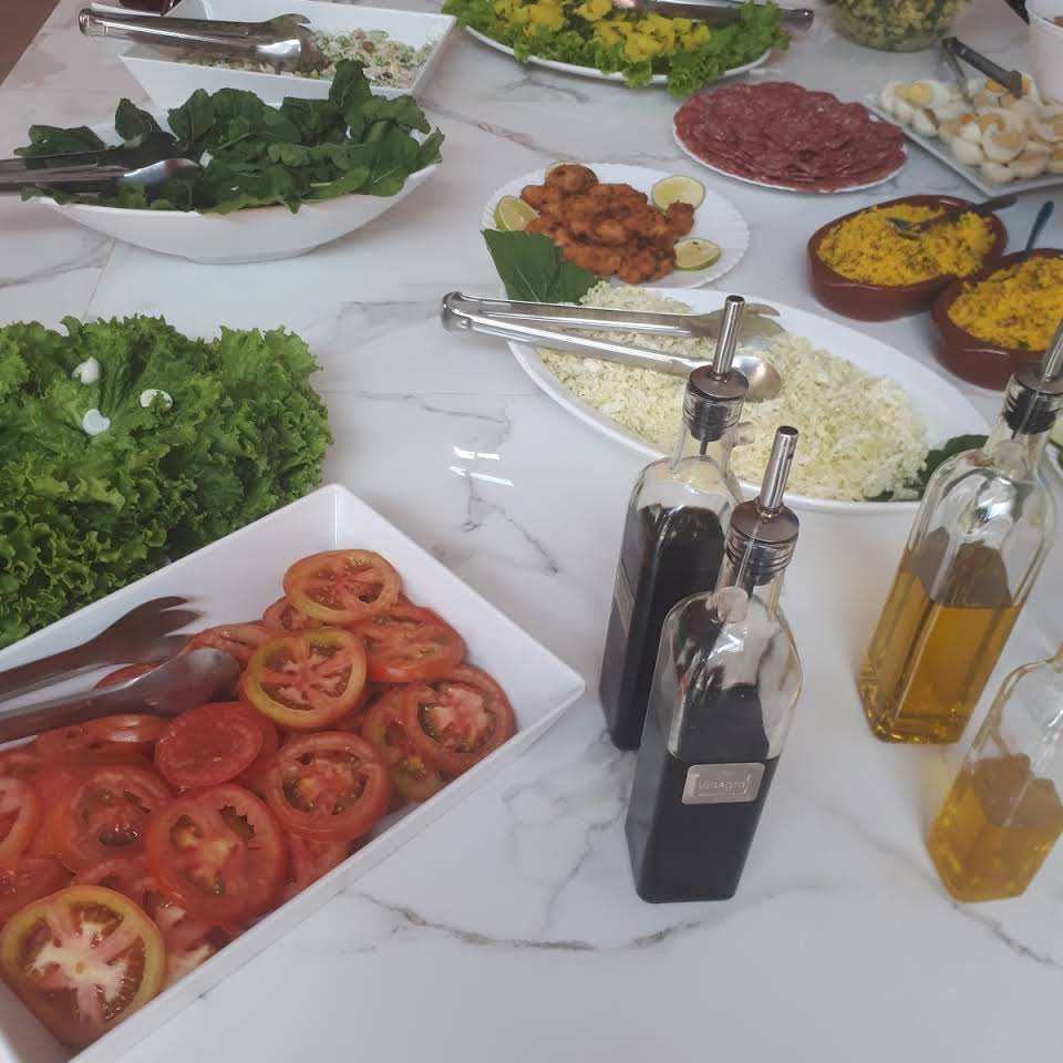 Buffet com diversas opções de carnes grelhadas, mais saladas e pratos quentes, em espaço arejado e informal.