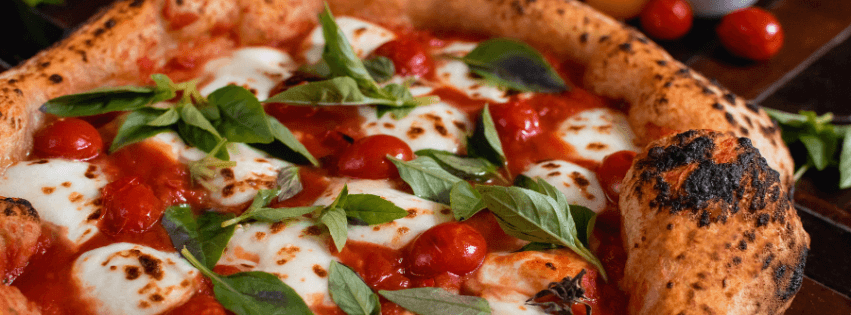 Cantina acolhedora fina de forno a lenha tem pizzas chamativas de ingredientes especiais com bordas e vinhos.